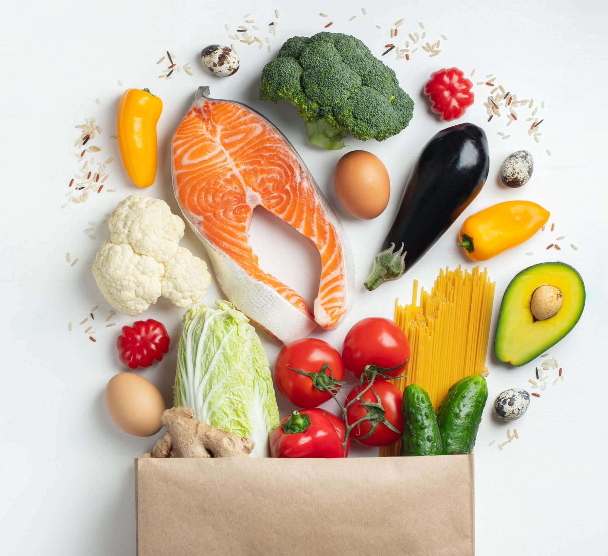 Supermarket. Paper bag full of healthy food on a white background. Top view. Flat lay. Copy space.